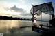 A woman sitting on a dock with a net over her head.