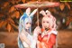 Two women dressed in bunny ears holding an umbrella.